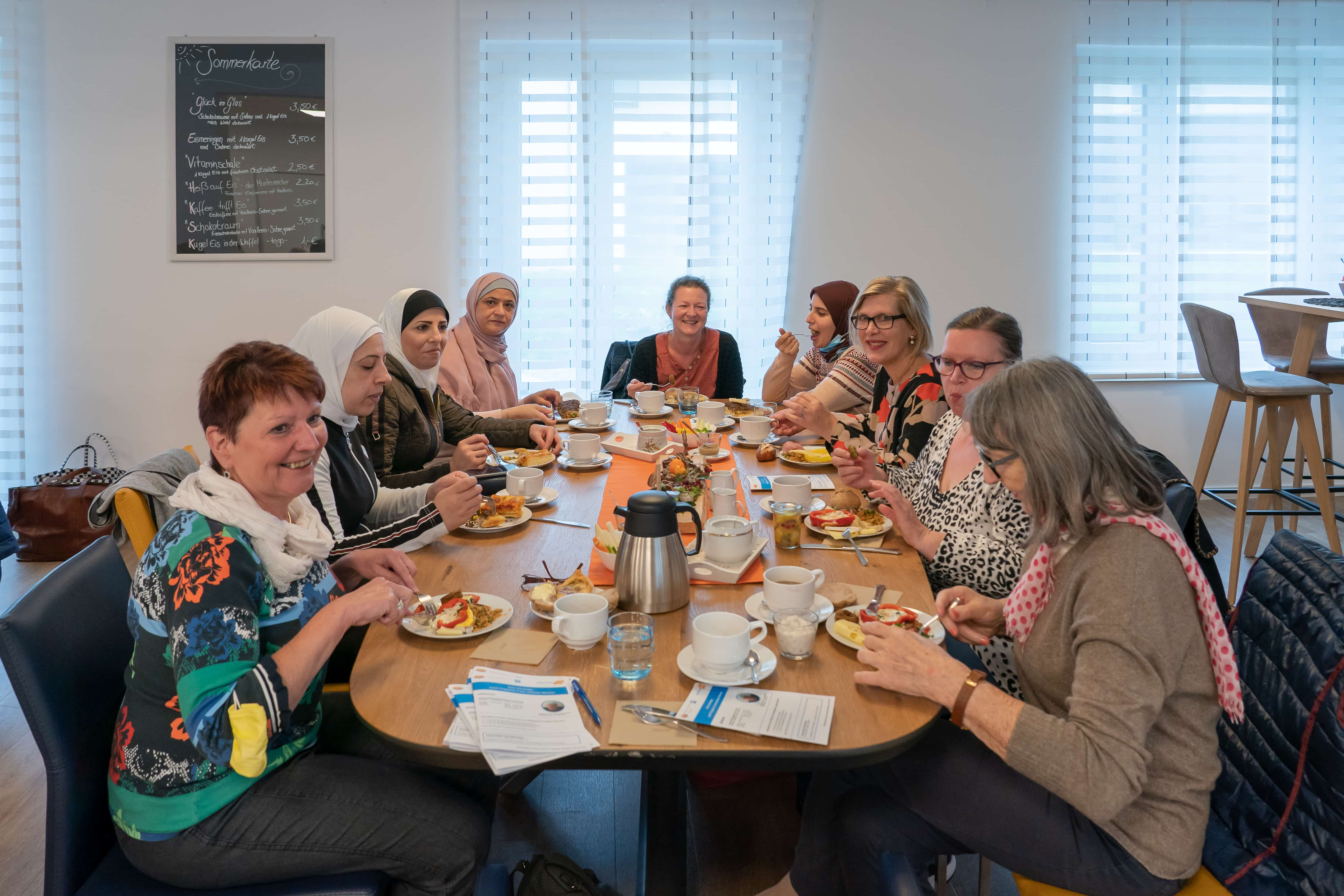 Mehrere Frauen sitzen an einem Tisch und frühstücken