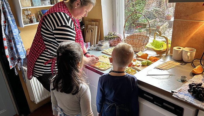 Eine Frau und zwei Kinder bereiten Essen zu