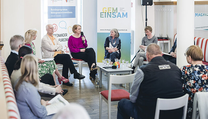 Bundesfamilienministerin Lisa Paus diskutiert mit einer Gruppe im Mehrgenerationenhaus