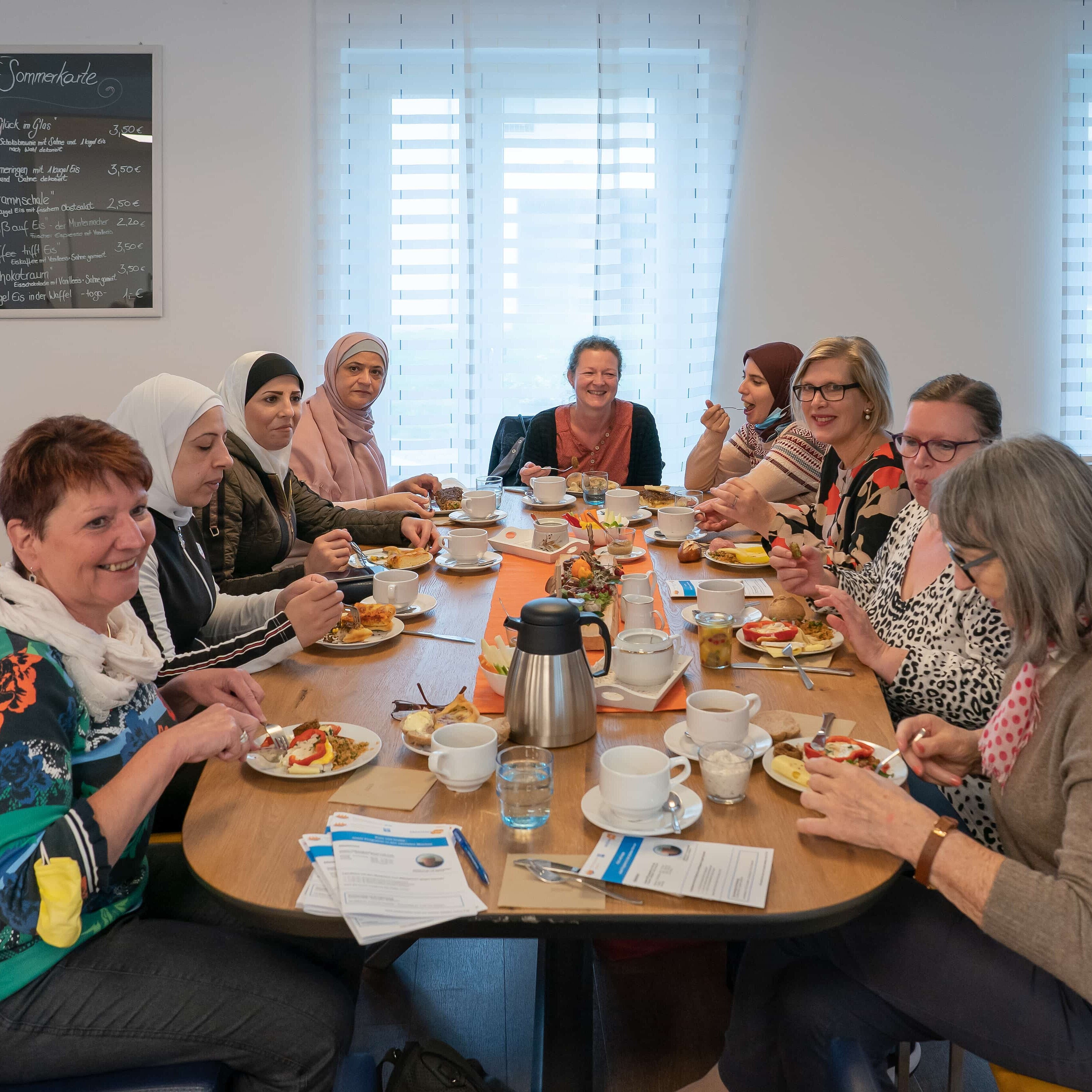 Mehrere Frauen sitzen an einem Tisch und frühstücken