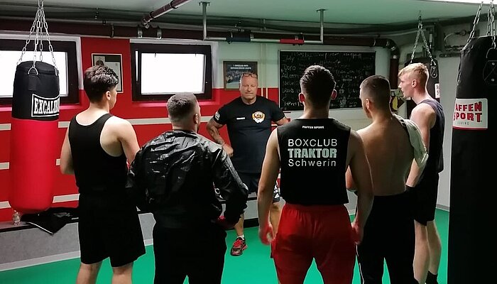 Deddy Krause mit Teilnehmenden des Boxtraining im Boxkeller des MGH Krebsförden